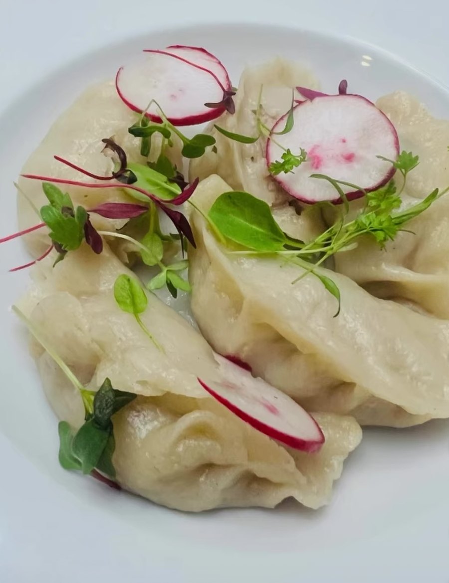 Plated gluten-free momo with radish and microgreens
